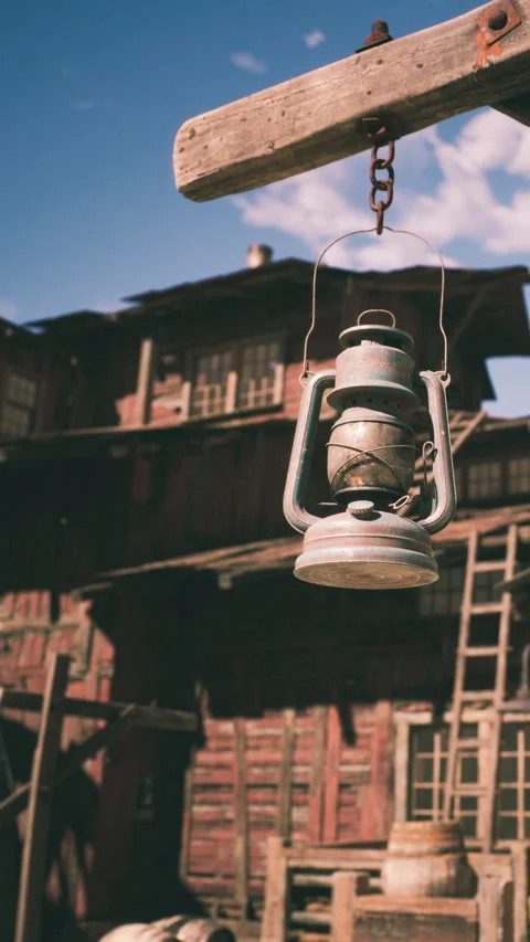 Rustic lantern hangs in front of wooden building during clear day Stock Footage 341050560