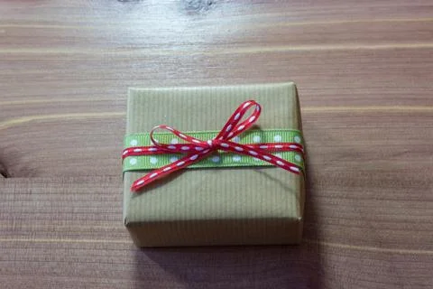 Rustic little gift box wrapped in brown kraft paper and tied with ribbons Stock Photos