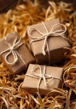 Rustic little gift boxes lie in natural wood shavings. Stock Photos