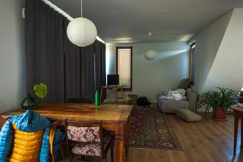 Rustic living space with dining table, sofa, and lantern lights Stock Photos