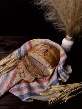 A rustic loaf of bread sliced and presented on a striped cloth Stock Photos