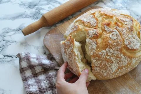 Rustic loaf of homemade bread close-up on wooden board on linen napkin with rock Stock Photos