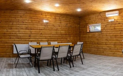 Rustic log cabin interior with wooden dining table and chair Fotos de archivo