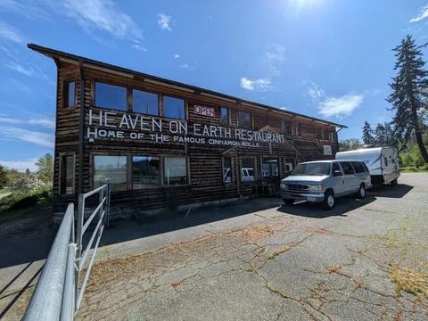 Rustic log cabin restaurant “Heaven on Earth” with famous cinnamon bun sign 库存照片