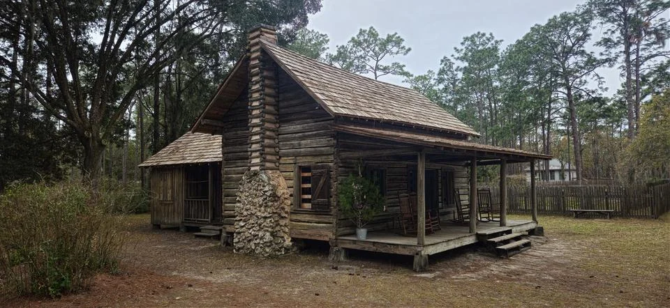 A rustic log cabin with a stone chimney Stock Photos
