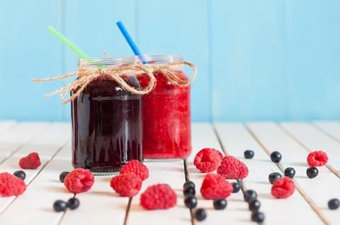 Rustic Mason Jars with raspberry jam and bog bilberry marmalade with fresh .. Stock Photos