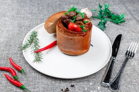 Rustic Meat and Vegetable Stew Served in a Bread Bowl with Herbs Stock Photos