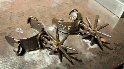 Rustic Metal Cowboy Spurs on Workbench in Close-Up Western Gear Detail Stock Footage 344042628