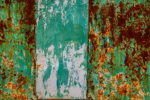 Rustic metal surface with peeling paint in industrial setting Stockfoto's