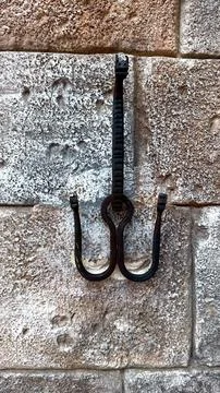 Rustic metalwork and stone showcasing rugged metal hook set against textured Stock Photos