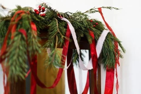 Rustic mirror decorated with fresh pine garland and long flowing red ribbon.. Stock-Fotos