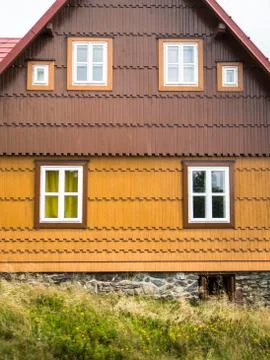 Rustic mountain cottage front in brown and yellow Stock Photos