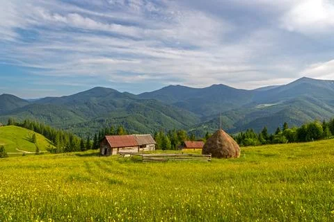 Rustic Mountain Farmhouse in Summer Landscape. Scenic rural farm with haystack Stock Photos