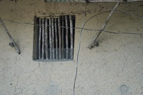 Rustic mud wall with bamboo window grate in a traditional rural village house ex Stock Photos