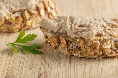 Rustic multigrain bread slice topped with fish spread. Stock Photos