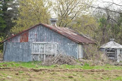 A rustic old barn with a chimney and a white door Stock Photos