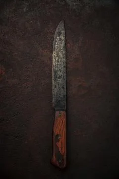 Rustic old kitchen knife with decayed carbon steel blade on rusty background Stock Photos