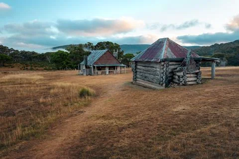 Rustic old log huts sit in a clearing in the high country Stock Photos