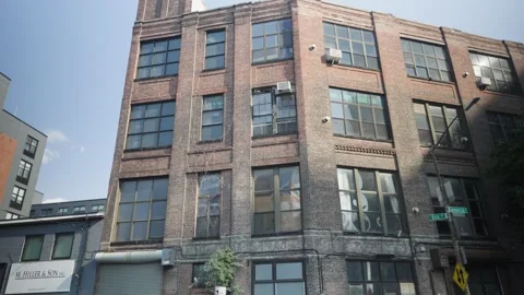 Rustic old red brick warehouse with giant bay windows in Greenpoint Brooklyn Stock Footage 243811449