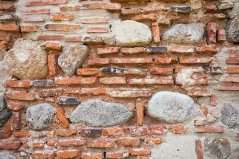 Rustic old wall background made of bricks and stones Foto stock