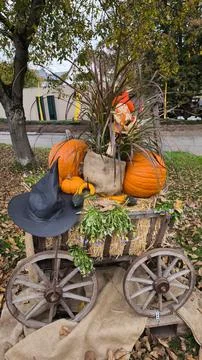 A rustic, outdoor autumn display centered around a small wooden cart with spo Stock Photos