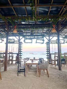 Rustic Outdoor Beachfront Cafe Decorated with Greenery Overlooking the Ocean Stock Photos