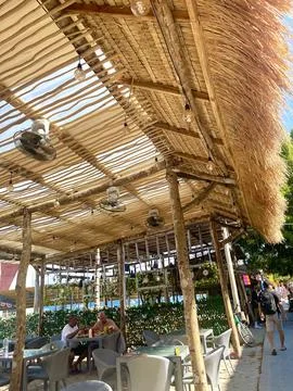 Rustic outdoor cafe under bamboo canopy with relaxed summer atmosphere Stock Photos