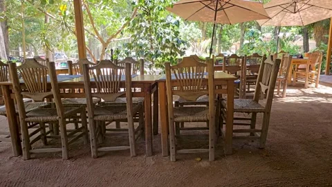 Rustic Outdoor Dining Setup Surrounded by Nature Stock Footage 283595176