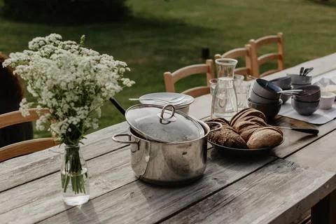 Rustic Outdoor Dining Table with Bread and Cookware in Garden Stock Photos