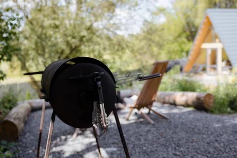 Rustic outdoor grill setup surrounded by nature at a cozy countryside retreat Stock Photos