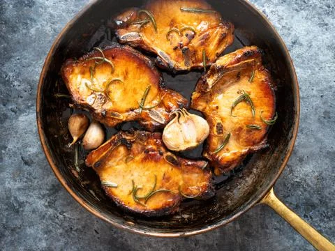 Rustic pan fried pork chops Stock Photos