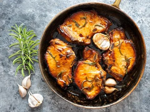 Rustic pan fried pork chops Stock Photos