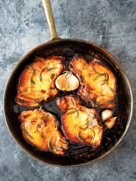 Rustic pan fried pork chops Stock Photos