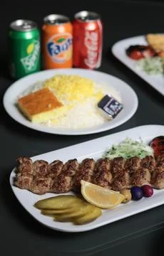 Rustic Persian dining scene featuring koobideh kebabs with saffron rice Stock Photos