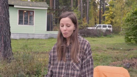 Rustic picnic in an autumn forest in a clearing. A young woman tastes fried Stock Footage 317752651