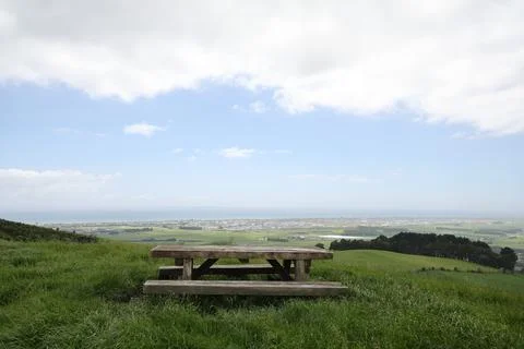 Rustic Picnic Bench Overlooking Coastal Farmland Valley Foto stock