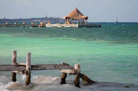 Rustic pier with thatched hut over turquoise waters in Puerto Morelos Stock-Fotos
