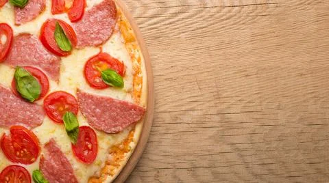 Rustic pizza with salami, mozzarella, cherry and a view of the basilica with  Stock Photos