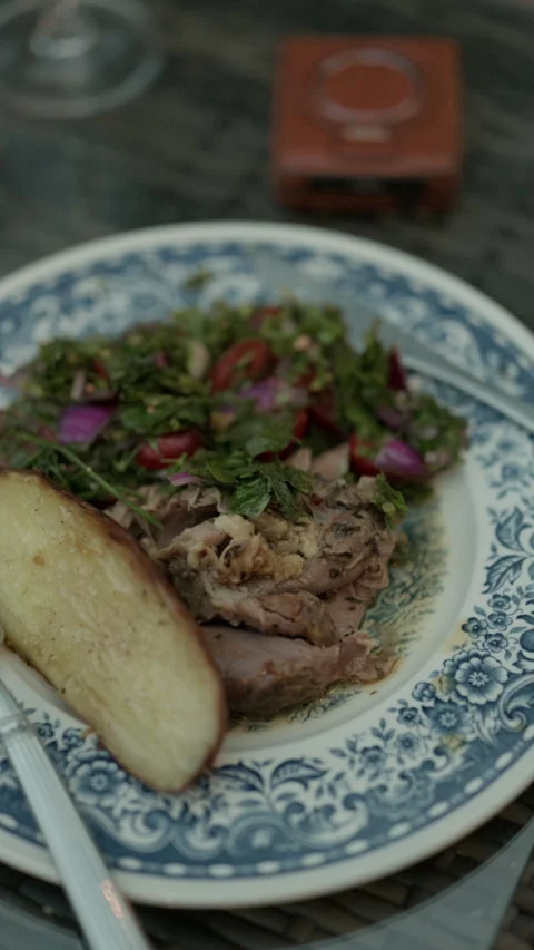 Rustic plated meal with roast meat, fresh herb salad, roasted potato wedge on Stock Footage 345266906