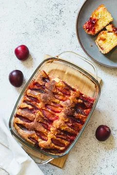 Rustic plum cake. Copy space. Top view, flat lay. Simple baking concept. Stock Photos