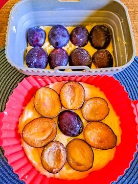 Rustic plum cake on wooden background with plums. Dough seasoned for baking Stock Photos