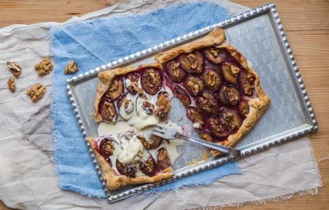 Rustic plum pie with walnuts and vanilla ice-cream Stock Photos