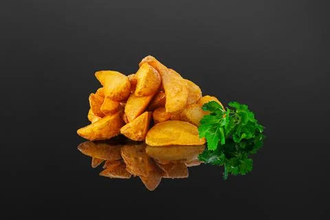 Rustic potatoes with herbs. Close-up. Isolated. Dark background. Reflection Stock Photos