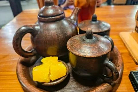 Rustic Pottery Tea Set with Yellow Sweet Treats on Wooden Table Stock Photos