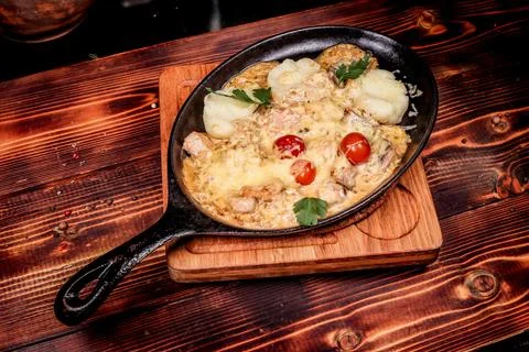 Rustic presentation of a hearty baked dish with meat or poultry, creamy chees Stock Photos