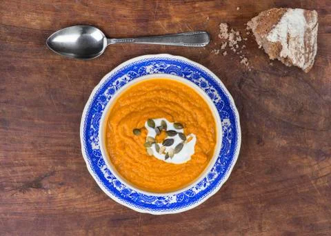Rustic pumpkin soup with bread on wood Stock Photos