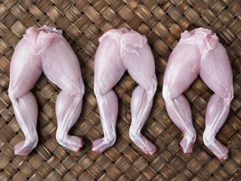 Rustic raw uncooked frog legs Stock Photos