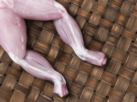 Rustic raw uncooked frog legs Stock Photos