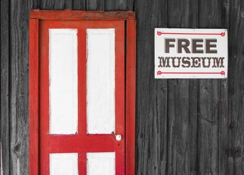 Rustic red and white door to a free museum Stock Photos