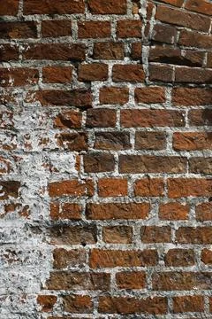 Rustic Red Brick Wall with Partial White Plaster in Sunlight Stock Photos
